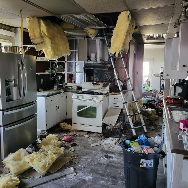 Yellow Van fire and smoke restoration team assessing a heavily damaged kitchen after a house fire.