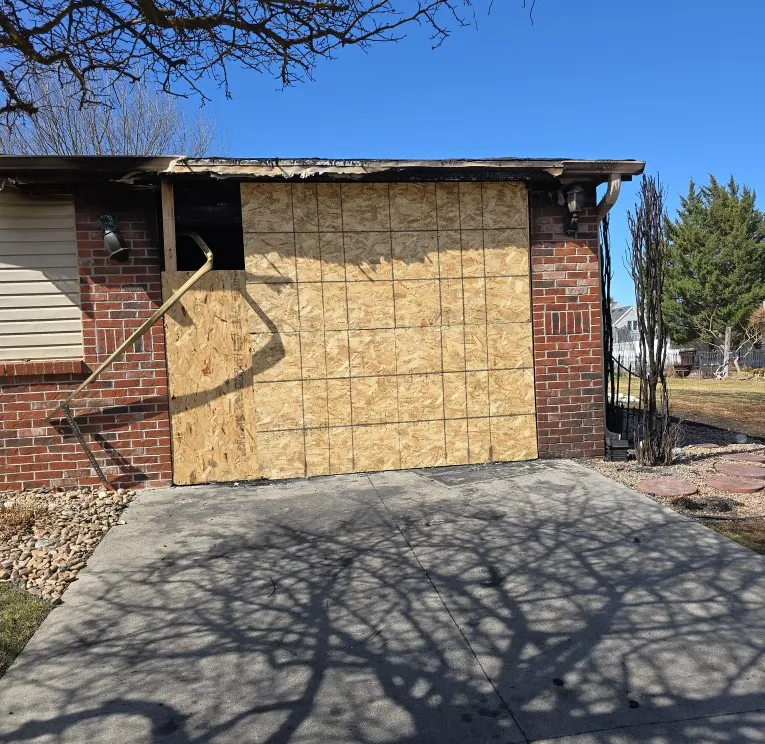 Emergency window and door plywood board-up to secure a property damaged by Nebraska storms.